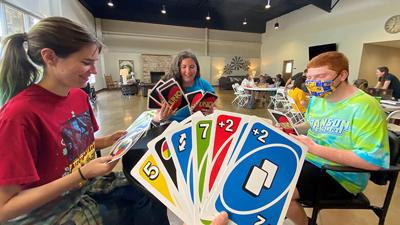 People play a game of Uno during a Little House of Neurodiversity respite day.