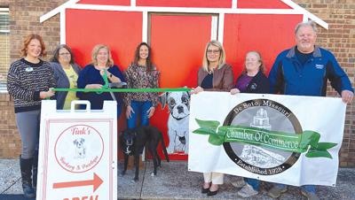 Owner Kris Haug holds the scissors for a De Soto Chamber of Commerce ribbon-cutting ceremony for Tink’s Barkery & Pawtique.