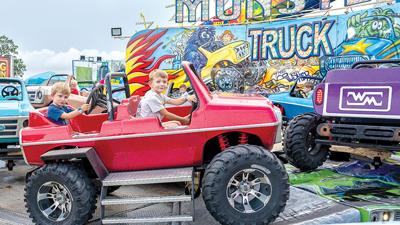 Cousins Dawson Buchner, 3, left, and Langston Ebert, 6, both from Hillsboro, go for a carnival ride at the Jefferson County Fair.