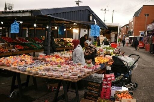 Shoppers peruse items for sale in Longsight outdoor market in the Gorton and Denton parliamentary constituency, which heads into a crunch election this week
