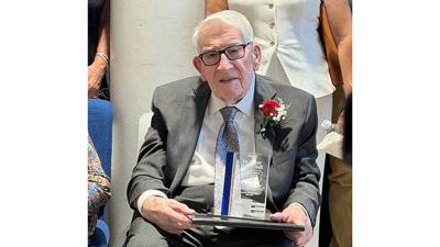 Dr. B. Ray Henry poses with an award commemorating the building renaming.