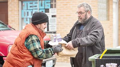 Tommy Marler, left, receives a meal from Jim McGuire of New Hope Fellowship Church.