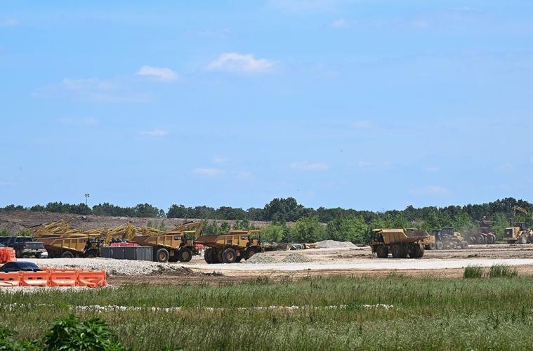 Large dump trucks traverse the construction site