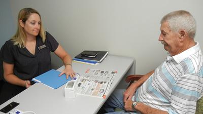 Society for the Blind and Visually Impaired representative Michelle Harrell with patient Emory Hicks, 84, of Festus during his recent visit to Premiere Eye Associates.