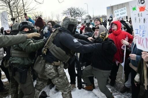 Federal officers clash with a large crowd of protesters outside a government facility near Minneapolis