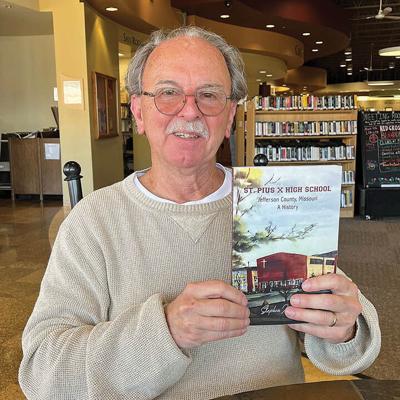 Steve Stoll holds a copy of his book. The cover is a watercolor painted by the late Sister Borgia Fehlig.