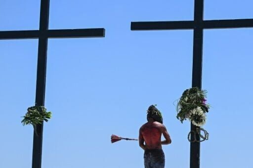 A penitent flagellates himself in front of the crosses prior to the annual crucifixion in the village of Cutud in the Philippines' Pampanga province