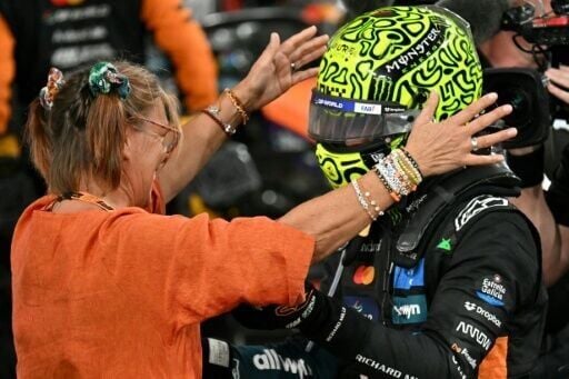 Lando Norris (R) gets a hug from his Belgian mother Cisco after winning the world championship in Abu Dhabi