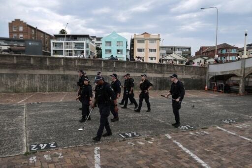 Police officers patrol near a small bridge where gunmen stood during a mass shooting in Bondi Beach last Sunday.