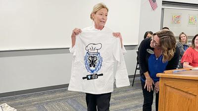 District Chef Tori Christie reacts after Jessica DiPaolo, Northwest’s director of administrative services, surprises her with a Northwest Lion chef coat.