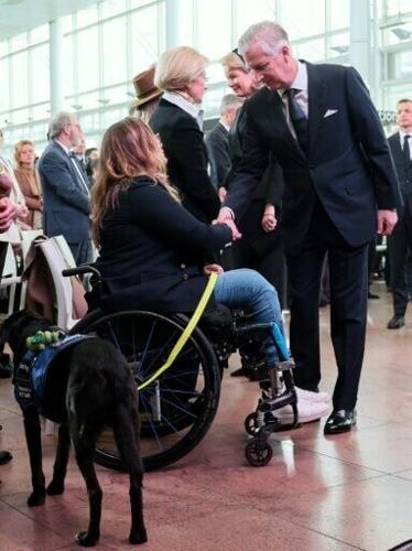King Philippe shakes hands with Beatrice de Lavalette, who became a Paralympic horse rider after losing her legs in the bombings