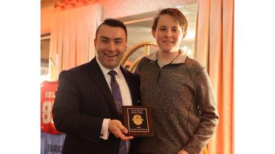 David Amelotti, the dinner’s emcee, presents Evan Bailey, representing Frankie Gianino’s, with the Food Favorite Award.