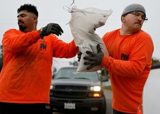 Los Angeles County workers load sandbags in preparation for a strong atmospheric storm set to hit southern California amid fears of flooding and mudslides