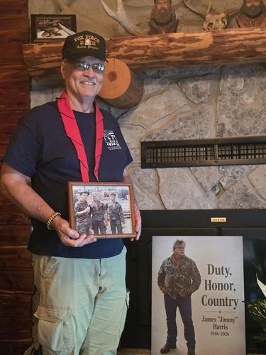 Kenny McLacklan holds a photo of Harris and himself when they were in Vietnam.