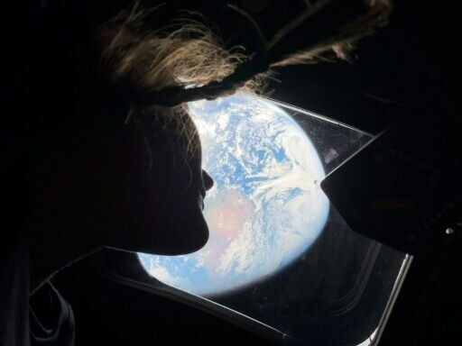This handout picture by an Artemis II crew member provided by NASA shows Artemis II mission specialist Christina Koch looking back at earth through the window of the Orion spacecraft on April 2, 2026