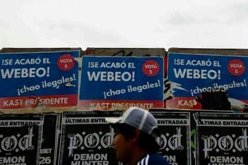 A person walks past posters supporting Chilean presidential candidate Jose Antonio Kast of the Republican Party in Santiago