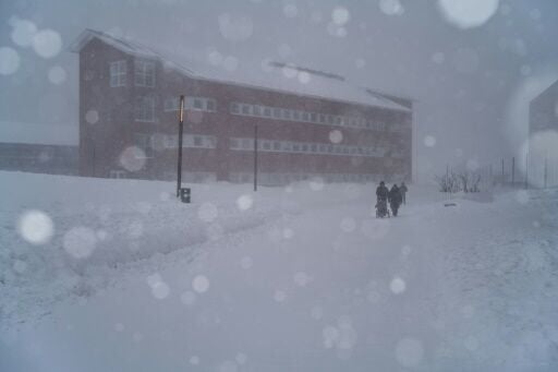 Two people walk through the streets during a snowstorm, in Nuuk, Greenland, on March 21, 2026