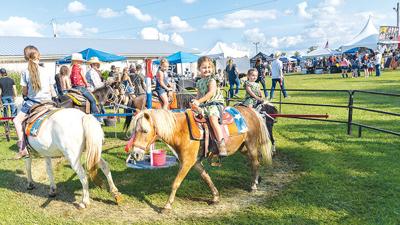 Myah Marciante, 5, of Hillsboro, center, rides a pony at the Jefferson County Rodeo last weekend, followed by her sister, Maisyn Marciante, 3, right.