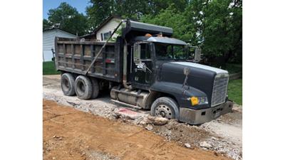 A dump truck delivering materials got stuck in the road in the Southern Aire subdivision off Arnold Tenbrook Road in Arnold because of damage to the streets.