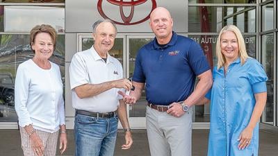 From left, Mary and John Poppell hand  off the Twin City Toyota keys to Todd Schutte and his wife, Michele.