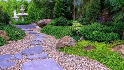 Stone stepping Walkway among lawn in a Japanese style garden. Landscaping in the garden