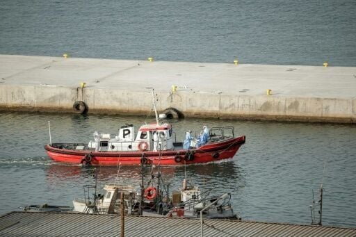 A small red ambulance boat sailed to the cruise ship on Wednesday