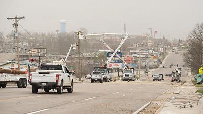 Crews work to repair downed power lines along Jeffco Boulevard in Arnold following the tornado that rolled through the county on March 14.