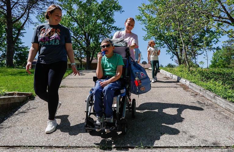 Aubrey Sandbothe, one of Carter’s caretakers, pushes Carter