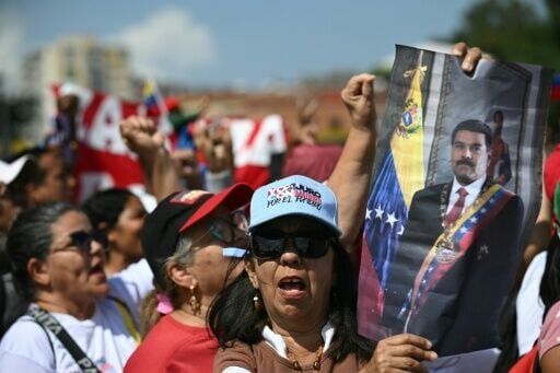 A demonstrator holds a picture of ousted Venezuela's president Nicolas Maduro during a rally to support him in Caracas on January 7, 2026