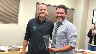 De Soto City Manager Todd Melkus, right, recognizes Rich McCane on Monday night for his years of service to the city. McCane resigned from the City Council due to moving outside the city limits.