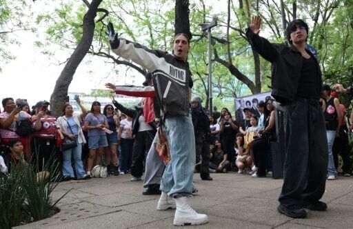 Los fanáticos del grupo surcoreano de K-pop BTS bailan durante una reunión en la Ciudad de México el 3 de mayo de 2026.