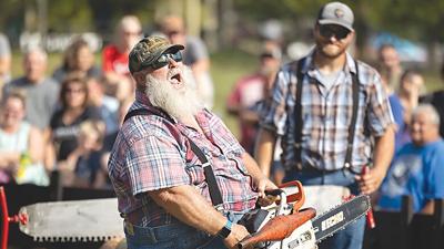 Lee LeCaptain of the Paul Bunyan Lumberjack Show shouts to the crowd at Arnold City Park during the 2022 Arnold Days celebration.