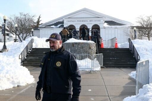 A police officer looks on as members of the media gather outside the Chappaqua Performing Arts Center