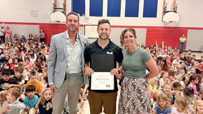Lone Dell Elementary School special-education teacher Brett Walters, center, on March 26 receives the Fox C-6 School District Teacher of the Year award from Lone Dell Principal Paul Tramel, left, and Assistant Principal Lindsay Gruenewald.