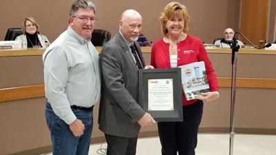 Arnold Commission on Aging and Disabilities chairman Bill Knittig, left, and Mayor Ron Counts, accept the city’s certificate declaring it part of the AARP Network of Age-Friendly States and Communities from Sheila Holm, community outreach director for A...