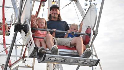 Ben Robinson and his children, Remi, 4, left, and Rutledge, 2, of Festus ride the Ferris wheel at last weekend’s Firecracker Festival in Crites Park.