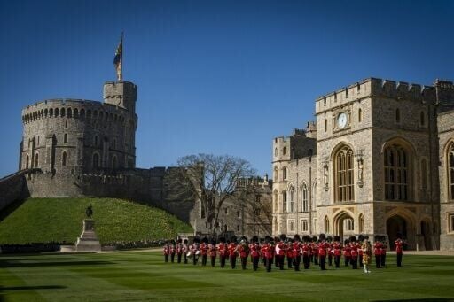 Members of the Band of the Grenadier Guards stand on the lawn in front of the Round Tower at Windsor Castle