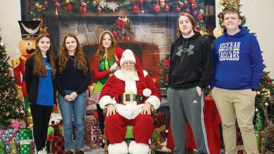 Members of the Seckman High School Key Club pose for a picture with Santa Claus at the 2024 Arnold Kiwanis Giving and Light Fair.