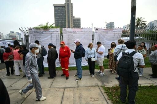 People wait in line outside a polling station in Lima on April 12, 2026, during general elections.