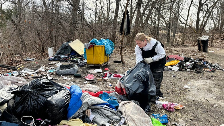 Karla Lefarth of Journey to a New Life Ministries of the First Baptist Church of House Springs cleans at the encampment in High Ridge a few days before it closes.