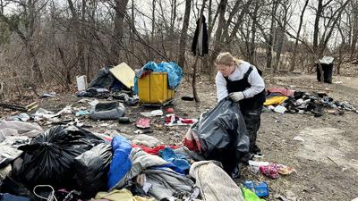 Karla Lefarth of Journey to a New Life Ministries of the First Baptist Church of House Springs cleans at the encampment in High Ridge a few days before it closes.
