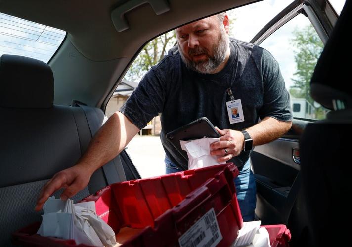 Chris Clubbs unloads prescriptions to make a delivery