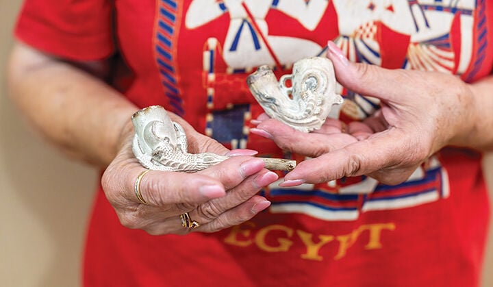 Kathie Roussin of De Soto shows off two pipes shaped like eagle talons.