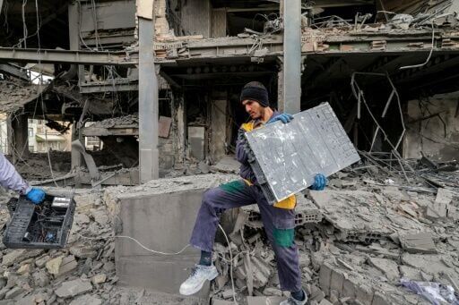 A man retrieves equipment from an office building in Tehran after a strike