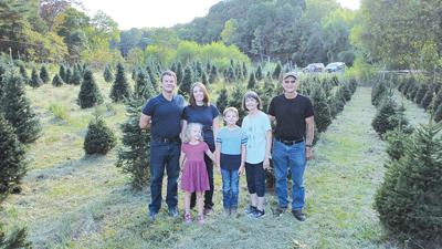 The Flinn family stands in front of some of their Christmas trees. From left are Kyle, Addie, Julia, Christian, Connie and Don Flinn.