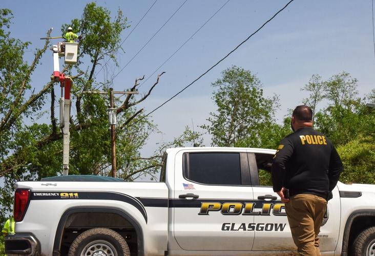 Glasgow Police Chief TJ Livermore watches as crews cut down fallen branches