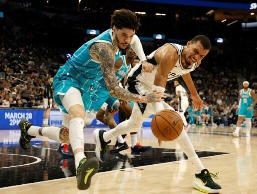 French star Victor Wembanyama, right, of San Antonio battles Charlotte's LaMelo Ball for a loose ball in the host Spurs' NBA victory over Charlotte