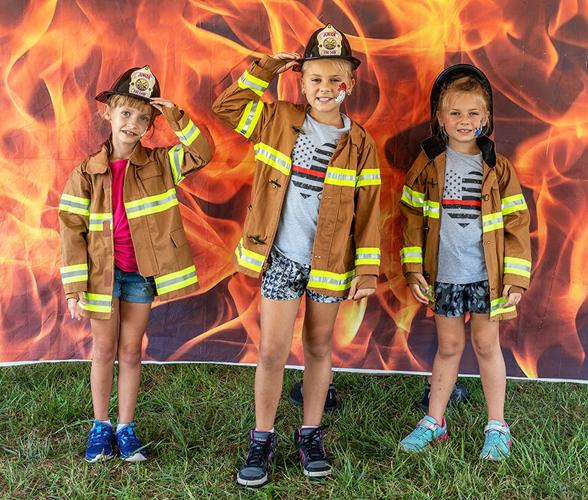 Tamara Maupin, 7, of Hillsboro, left, Rilynne Delarber, 8, of De Soto and her sister, Leanna, 6, pose as firefighters.