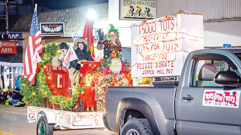 The Toys for Tots float rides down Festus Main Street at the Twin City Christmas parade on Monday.
