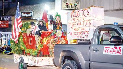 The Toys for Tots float rides down Festus Main Street at the Twin City Christmas parade on Monday.